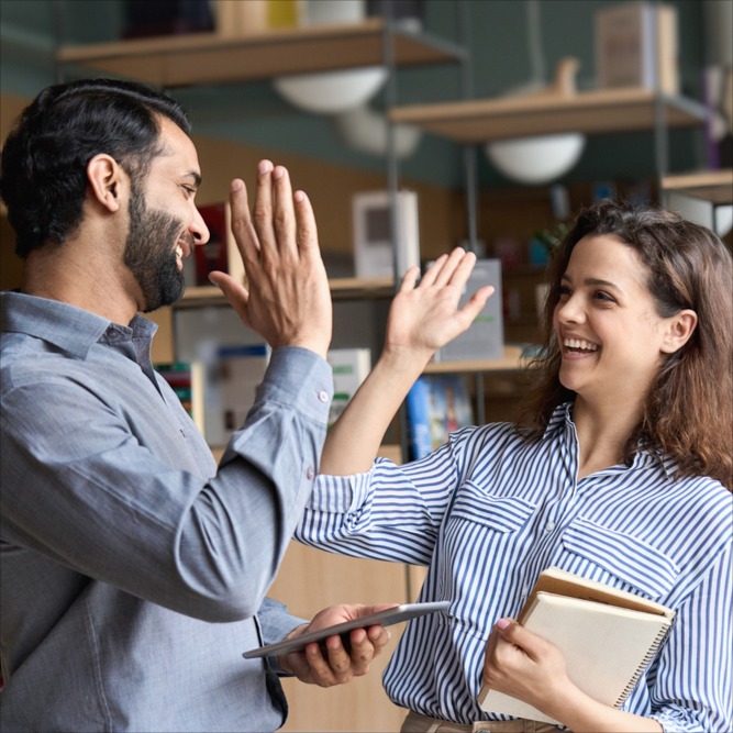 Two people high five each other